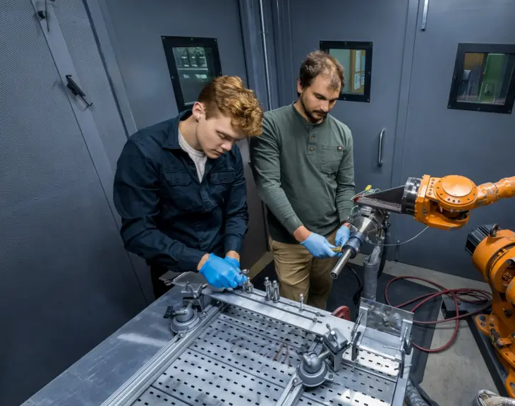 Students Evan Willing and Tyler Dabney set up cold spray equipment